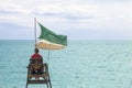 Lifeguard on the seafront. Guarded beach, watchtower with a green flag.