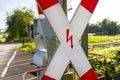 Guarded railroad crossing in the countryside with open barriers and cross of Saint Andrew. Royalty Free Stock Photo