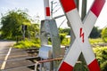 Guarded railroad crossing in the countryside with open barriers and cross of Saint Andrew. Royalty Free Stock Photo