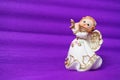 Guardian angel plays the flute. Figurine of a red-haired girl in a white dress with wings and a pipe. New Year or Royalty Free Stock Photo