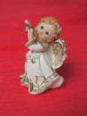 Guardian angel plays the flute. Figurine of a red-haired girl in a white dress with wings and a pipe. New Year or Royalty Free Stock Photo