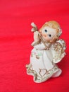 Guardian angel plays the flute. Figurine of a red-haired girl in a white dress with wings and a pipe. New Year or Royalty Free Stock Photo