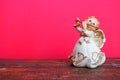 Guardian angel plays the flute. Figurine of a red-haired girl in a white dress with wings and a pipe. New Year or Royalty Free Stock Photo