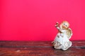 Guardian angel plays the flute. Figurine of a red-haired girl in a white dress with wings and a pipe. New Year or Royalty Free Stock Photo