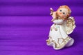 Guardian angel plays the flute. Figurine of a red-haired girl in a white dress with wings and a pipe. New Year or Royalty Free Stock Photo