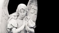 Guardian angel sculpture with open wings isolated on wide banner black background with empty text space. White angel sad expressio