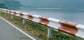 Guardrail traffic barrier painted red and white block road line on crest reservoir dam Royalty Free Stock Photo