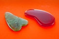 Guasha scrapers for body massage according to the ancient method shot on a bright red background