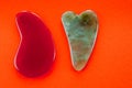 Guasha scrapers for body massage according to the ancient method shot on a bright red background Royalty Free Stock Photo