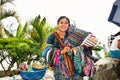 Guatamalian woman salling traditional colorful fabric at the street market in Panajachel, Guatemala.