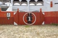 A red wooden gate art inside guatavita`s town bullring at sunny morning