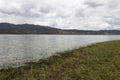 Guatavita Lake grass shore with sky water reflection