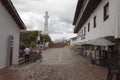 Guatavita main square alley entrance with chairs and umbrellas and clock tower