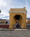 Public lavoir in the town of Antigua Guatemala, yellow walls, people standing under archway