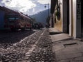 School kids cross street in front of colorful public bus, road is cobblestone Royalty Free Stock Photo