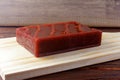 Guava candy in bar known in Brazil as Goiabada, isolated on wooden board. Guava sweet