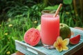 Guava smoothie in glass with bamboo drinking straw