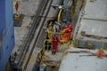 Stevedores which wearing safety protective clothes and helmets, discussing about cargo operation.