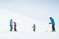 Gudauri, Georgia - 24th january, 2022: Caucasian male ski instructor teaching to ski family two kids and father beginner skier in