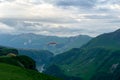 Gudauri, Kazbegi, Georgia: people paragliding through the Devils Valley in the Caucasus mountains. In the background the colorful