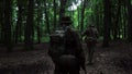 Guerilla partisan warriors walking in forest ambush carrying their guns.