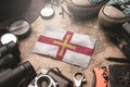 Guernsey Flag Between Traveler`s Accessories on Old Vintage Map. Tourist Destination Concept