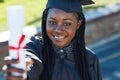 Guess who just graduated. Portrait of a young student holding her diploma on graduation day. Royalty Free Stock Photo