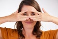 Guess who. Studio shot of a young woman covering her face with her hands against a white background. Royalty Free Stock Photo