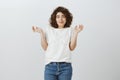 Guess you right, I do not know. Portrait of unaware cute curly-haired caucasian woman shrugging, making excusing face Royalty Free Stock Photo