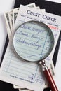 Guest Check and magnifying glass Royalty Free Stock Photo