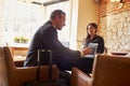 Guest checking in at hotel reception using tablet computer Royalty Free Stock Photo