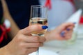 Guest holds glass with bubbly champagne in weddind. Wedding details in close-up view