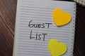 Guest List write on a book with keywords isolated wooden table