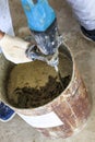 guest worker. the master kneads the solution for plastering. metal bucket. natural process