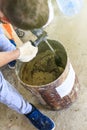 guest worker. the master kneads the solution for plastering. metal bucket. natural process