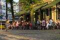 Guests eating and drinking in a restaurant in the center of Berlin. The fully occupied tables and chairs stand on the sidewalk in