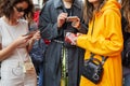 Guests looking at smartphone before Blumarine fashion show, Milan Fashion Week street style