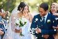 Guests throwing confetti over bride and groom as they walk past after their wedding ceremony. Joyful young couple Royalty Free Stock Photo