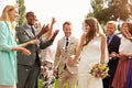Guests Throwing Confetti Over Bride And Groom At Wedding Royalty Free Stock Photo