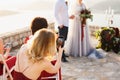 Guests at the wedding ceremony filming the bride and groom on the phones