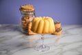 Gugelhupf ring cake, muffins, Italian puff pastry fan wavers cookies biscuits as selection buffet on marble table and lilac Royalty Free Stock Photo