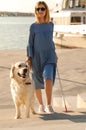 Guide dog helping blind person with long cane going up stairs