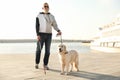 Guide dog helping blind person with long cane walking