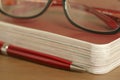 Guide, red ballpoint pen and glasses Royalty Free Stock Photo