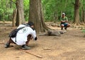 Guide taking photos of tourist with komodo dragon