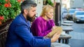 Guide to dating. Meeting people with similar interests. Man and woman sit cafe terrace. Girl interested what he reading Royalty Free Stock Photo