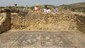 Guide with tourists at the House of Dionysus at the Archaeological Site at Volubilis, Morocco.