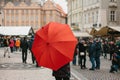 A guide with a traditional red umbrella on the Old Town Square in Prague invites tourists to visit the sights. Tourism