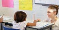 Guiding female student through math problems at classroom desk, with pencils and pink sticky notes Royalty Free Stock Photo