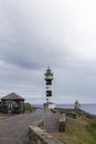 Guiding Light Amidst the Storm: A Striped Lighthouse Overlooking the Ocean Royalty Free Stock Photo